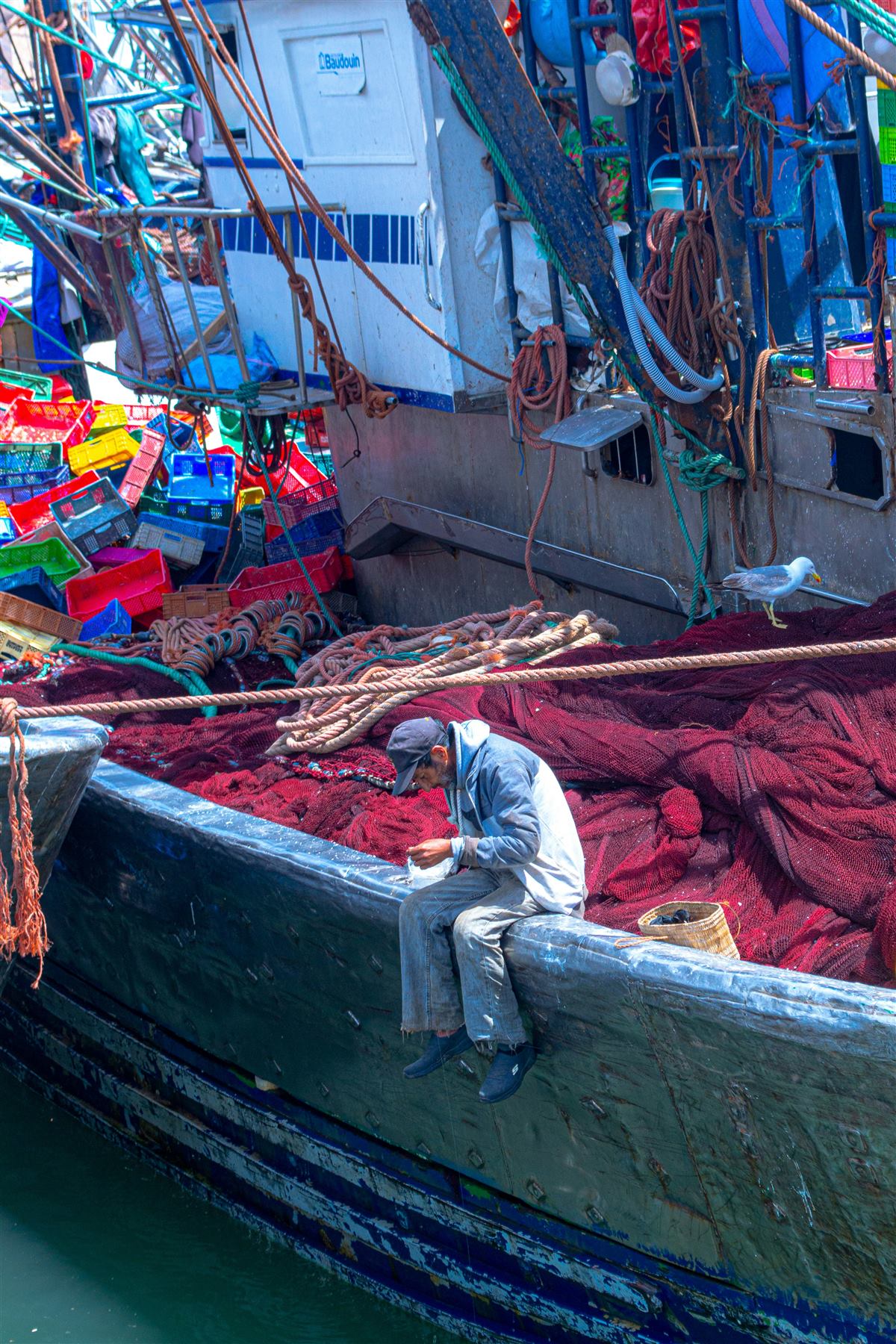 Fisherman mending nets on a Moroccan Atlantic boat