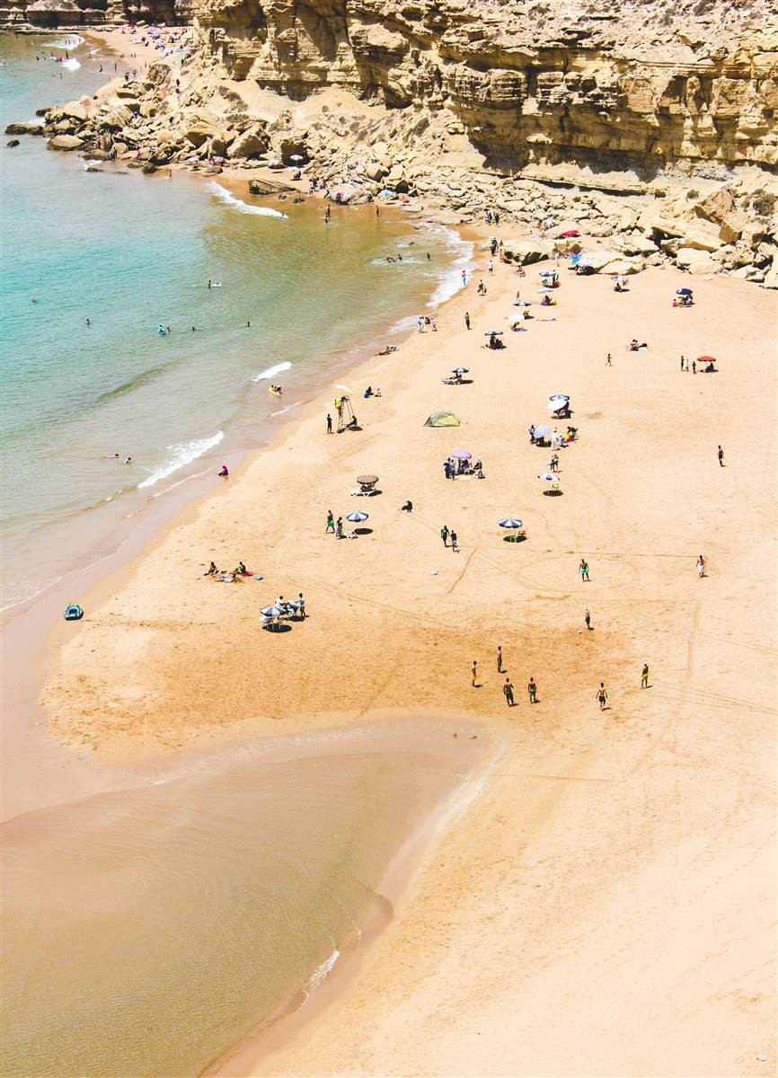 Sunny cliff cove beach with turquoise water Agadir Morocco