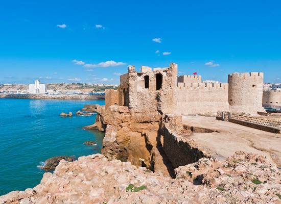 Stone sea fortress on cliffs above turquoise water Safi Morocco