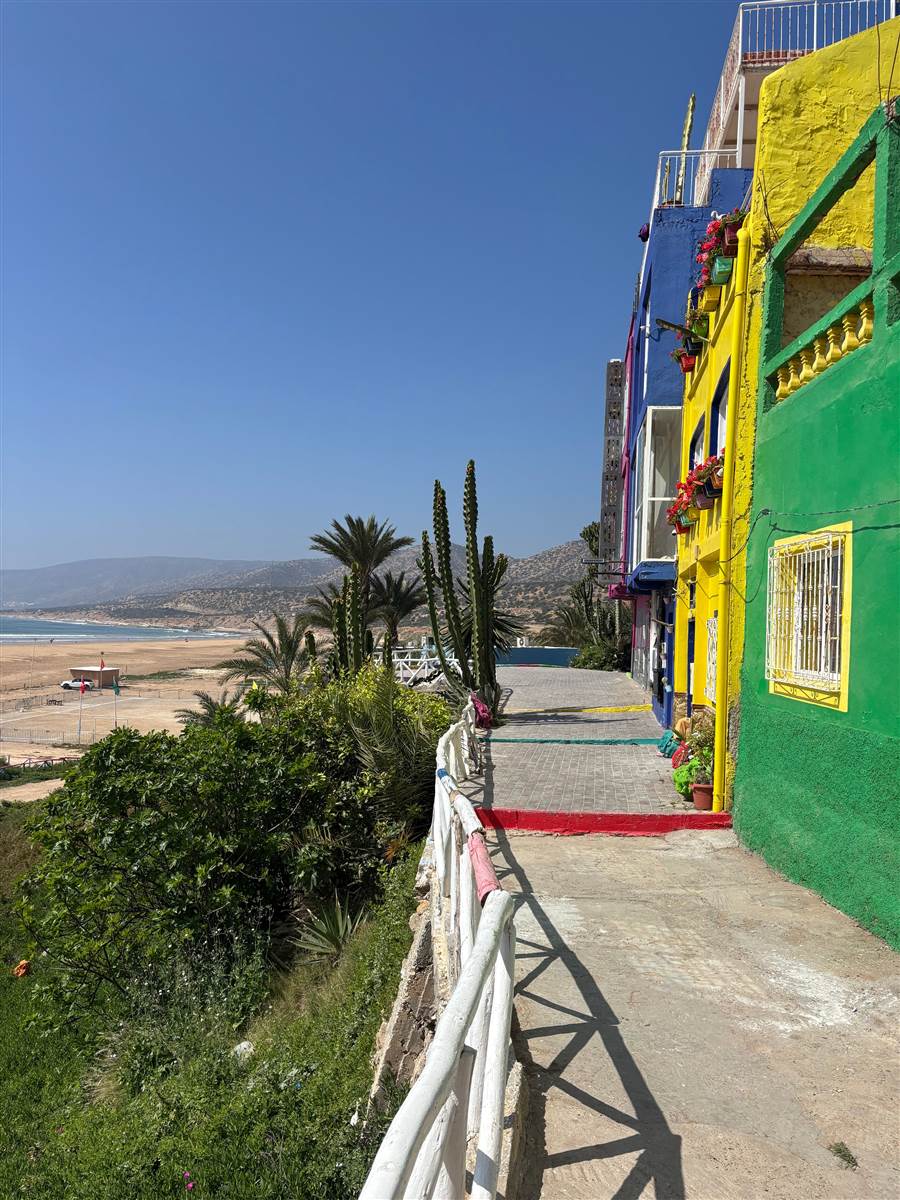 Colourful surf houses above sandy beach Taghazout Morocco