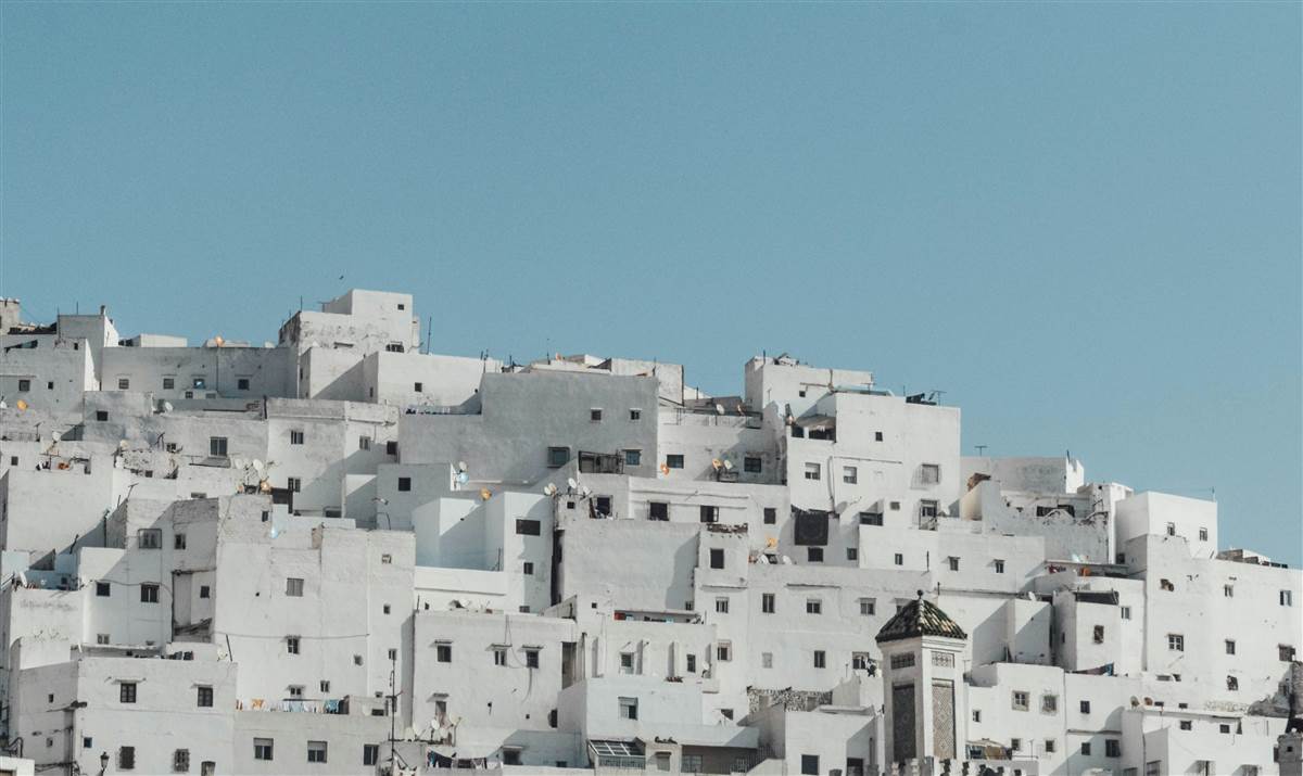 Whitewashed hillside medina houses under blue sky in Tetouan White Dove Morocco