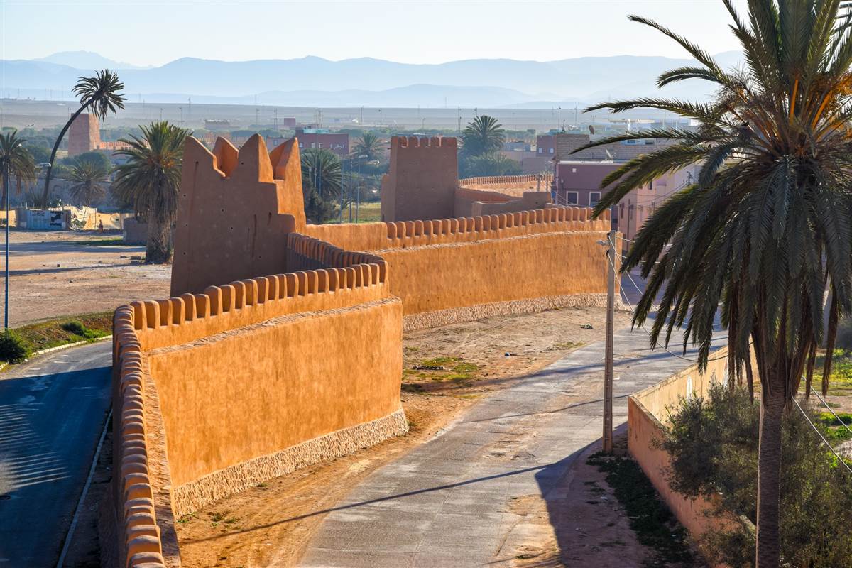 Tiznit ochre rampart walls with palm trees Morocco